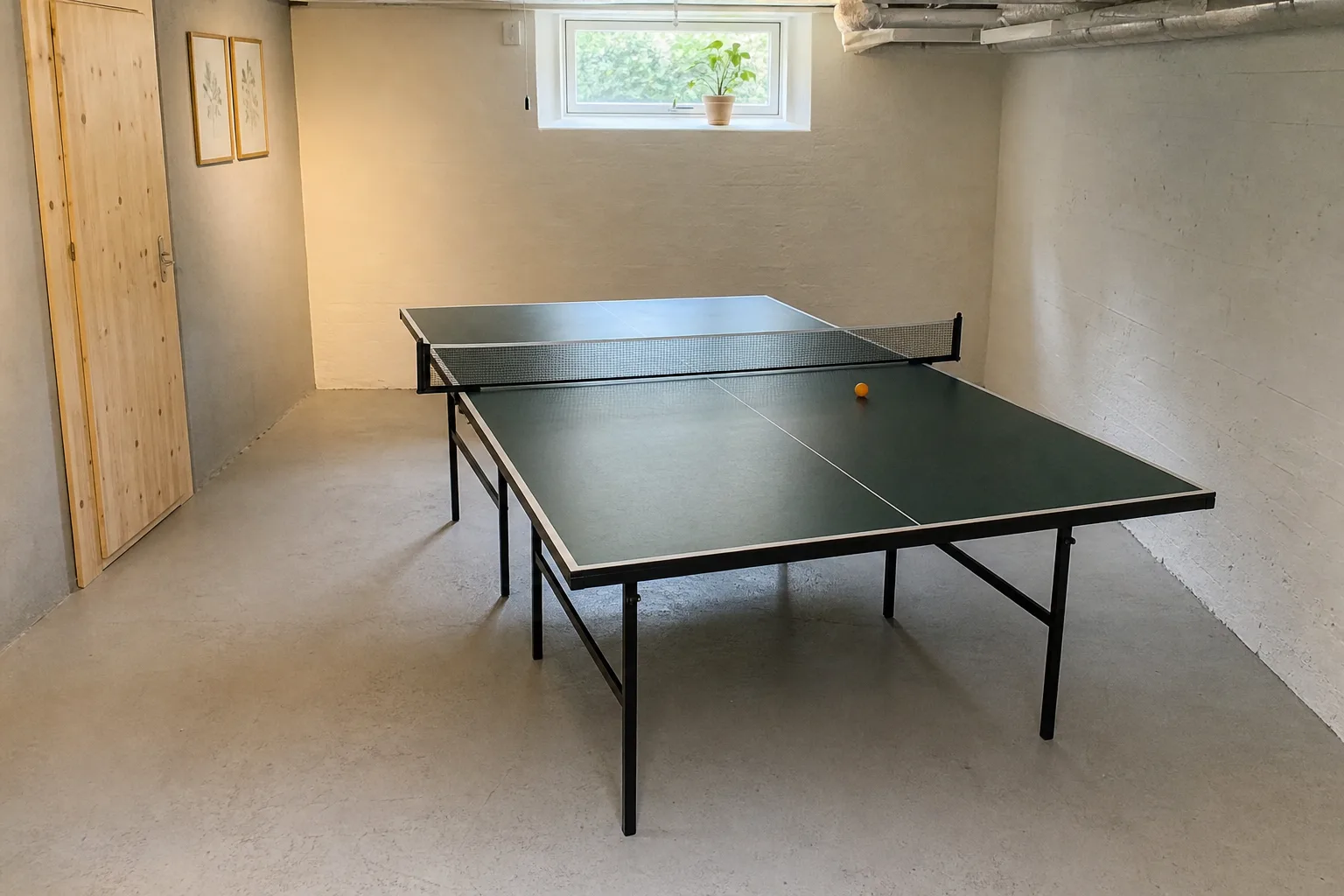 Pingisbord med synlig fri golvyta längs kortsidor och långsidor i ett källarrum.